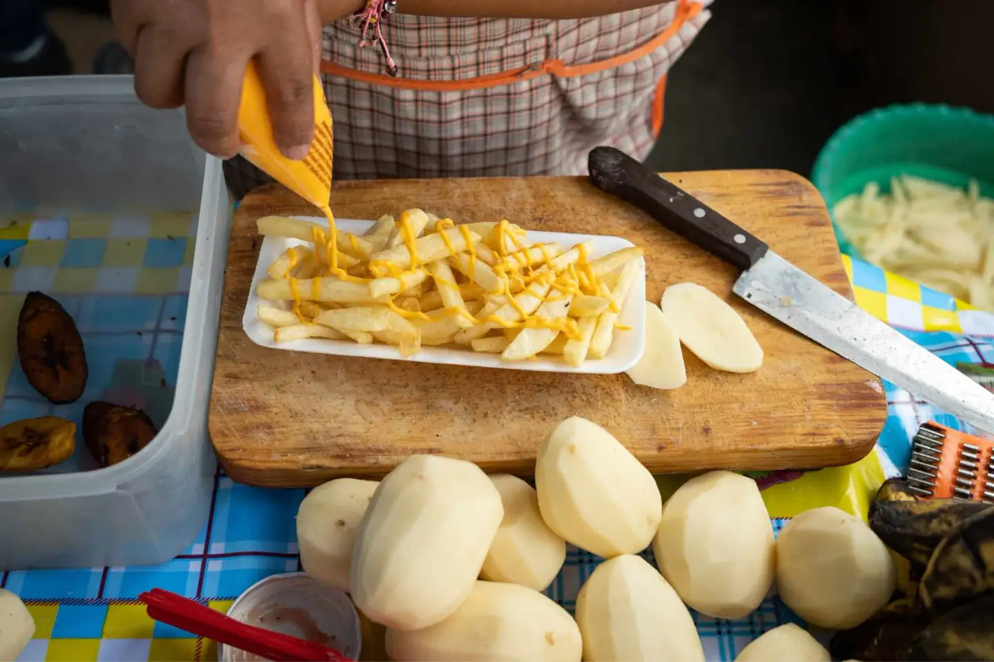 Fresh-cut fries with cheese sauce being prepared as a burger side